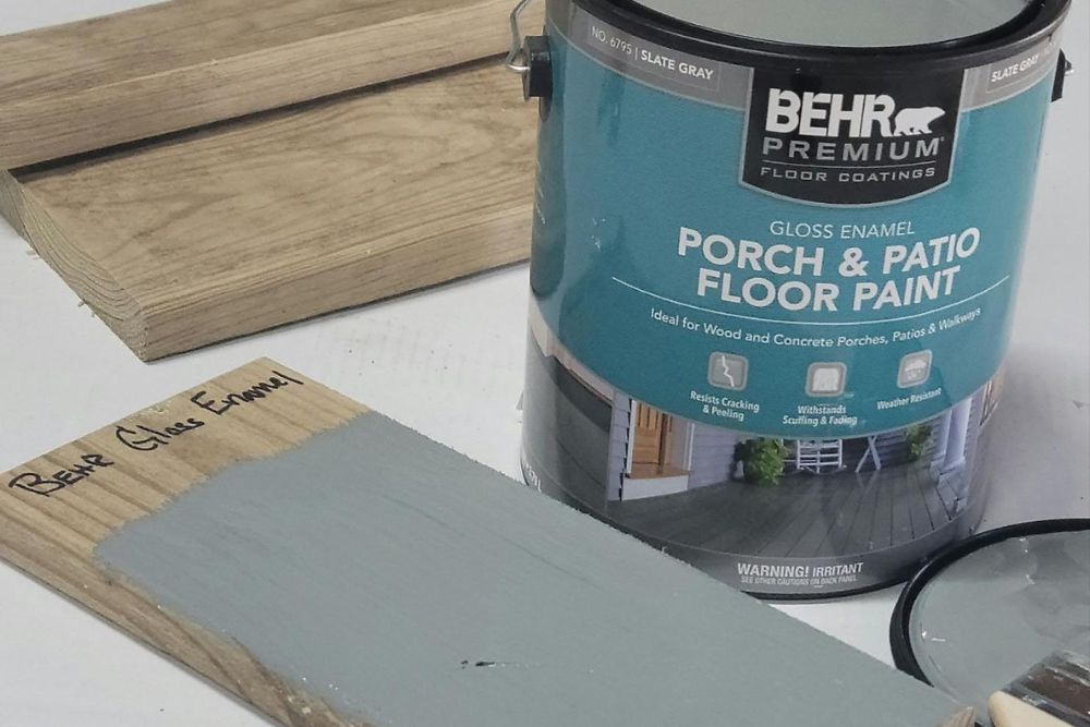 An open can of Behr porch and patio floor paint on a white table
