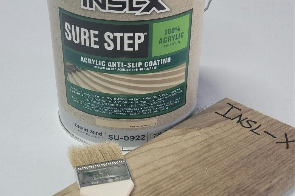 An open can of INSL-X deck paint on a white table