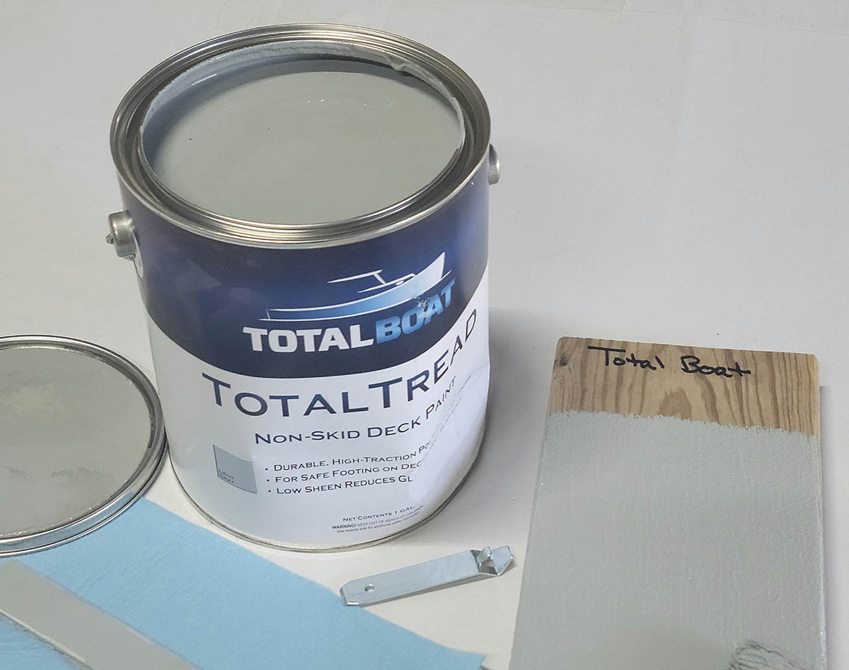 An open can of Total Boat deck paint on a white table