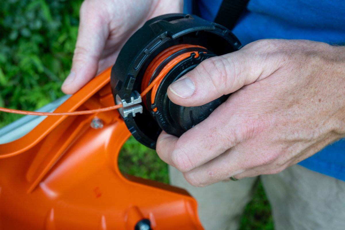 Person winding one of the best weed eater strings onto a string trimmer