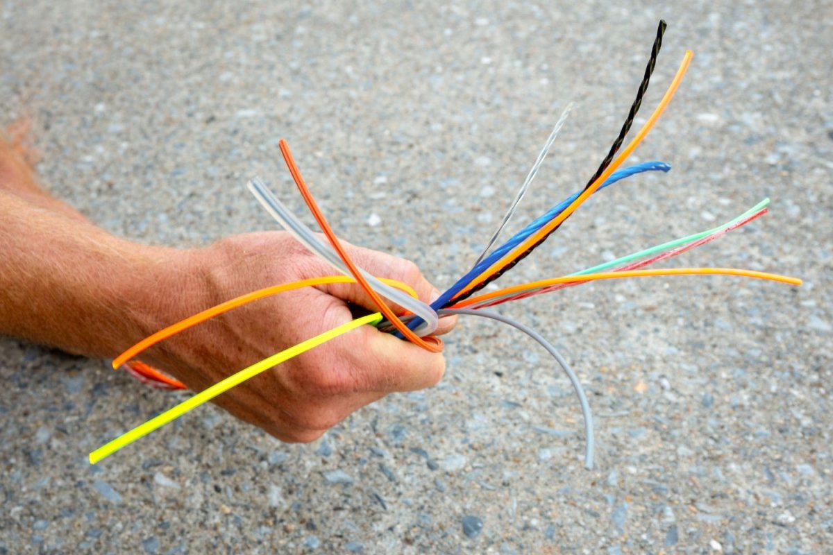 Person holding several of the best weed eater strings in hand