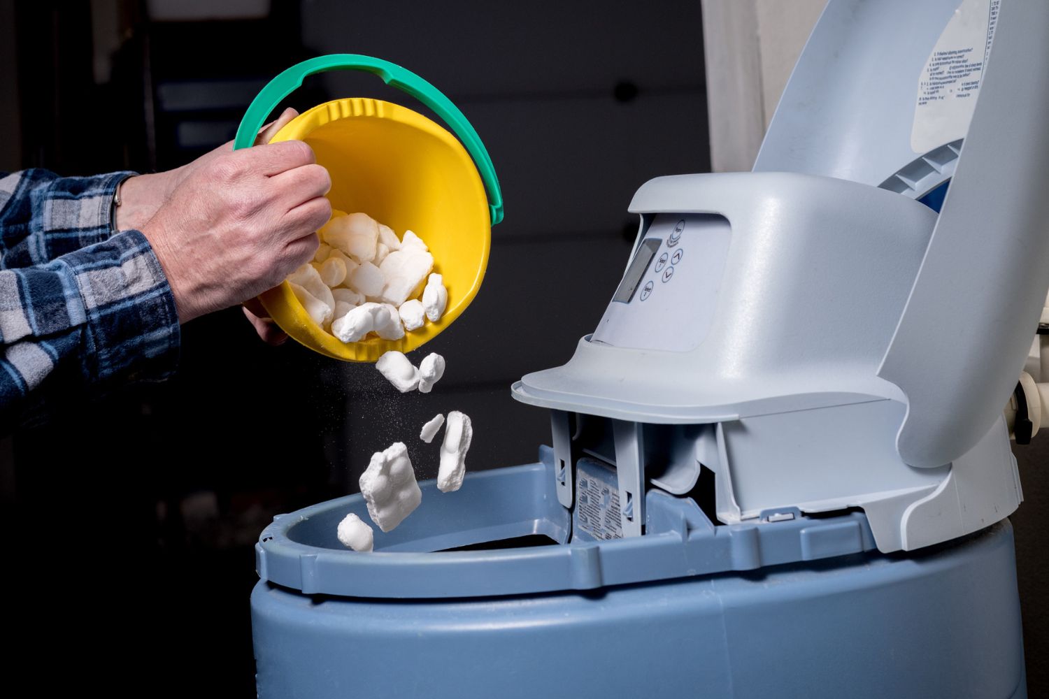 A person adding salt to the best water softener option