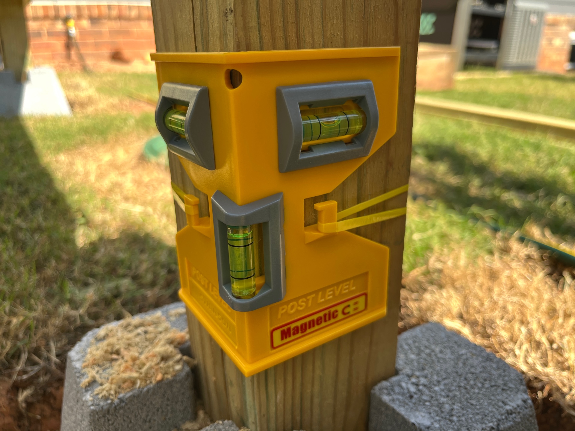 close-up of yellow Swanson post level in wood fence post