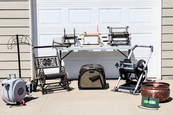 Eight hose reels on a driveway in front of a garage door