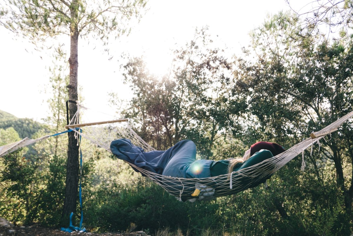 Someone relaxing in a hammock outside among the trees