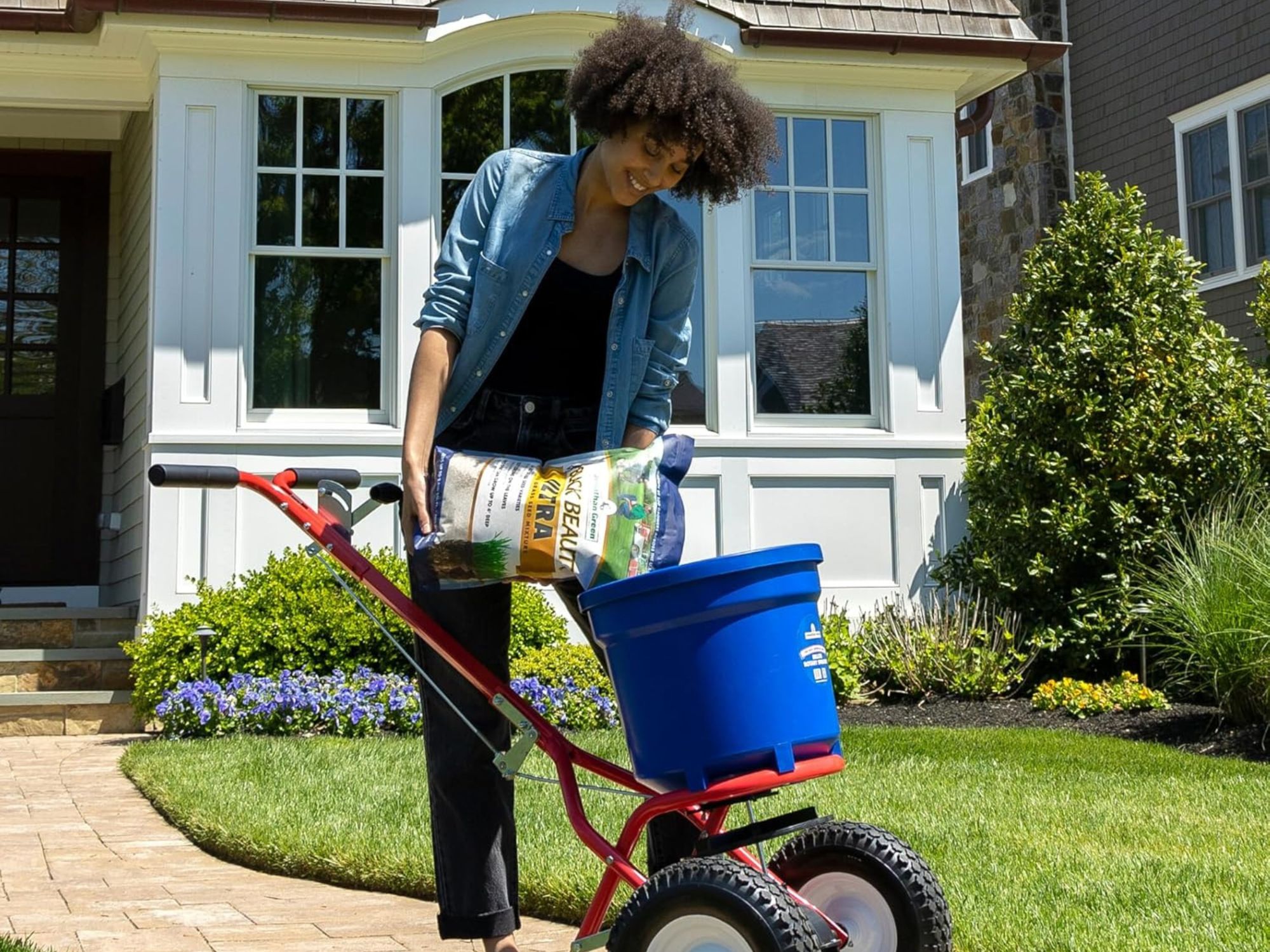 a woman putting one of the best grass seed option in a wheel barrow