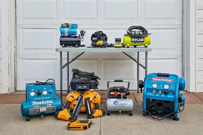 A group of the best portable air compressors in front of a garage door before testing.