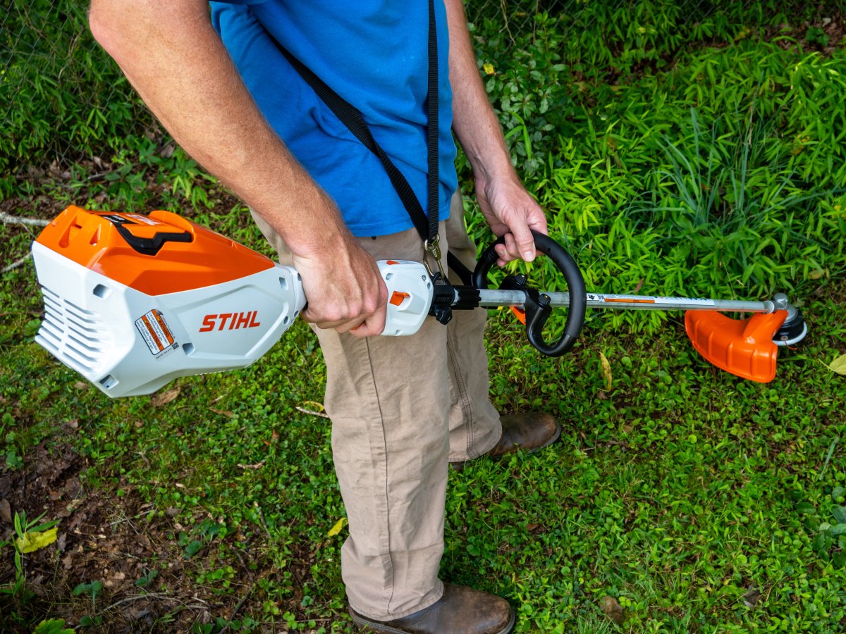 Bob Vila writer holding Stihl FSA 80 R Battery-Powered String Trimmer during battery trimmer testing.