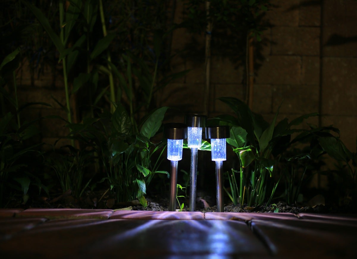 A set of three outdoor walkway lights illuminate front walkway at night.