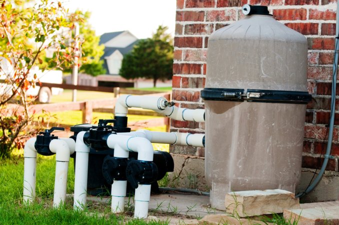 The Best Pool Pump Option set up next to the corner of a building