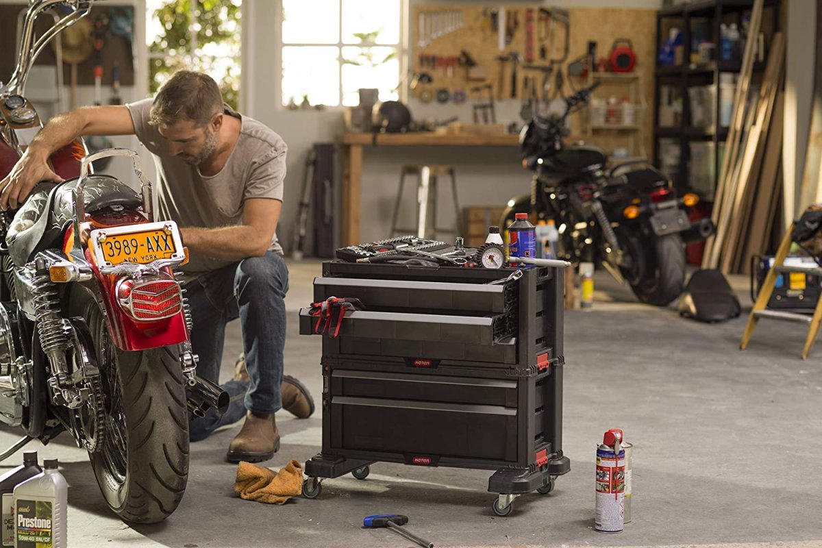 The best rolling tool box option next to someone using tools to work on a motorcycle