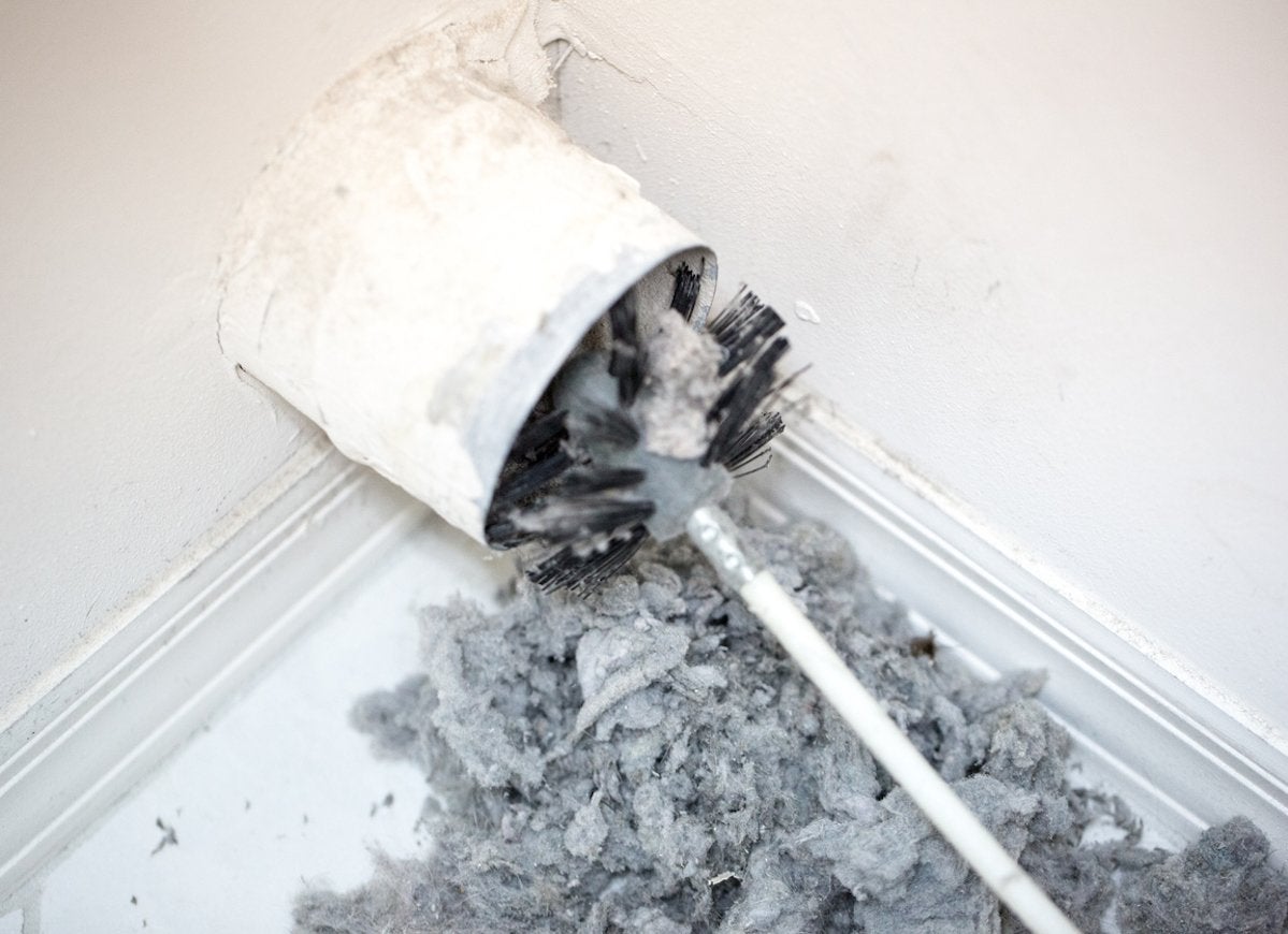 Using a toilet brush to clean lint from a dryer vent.