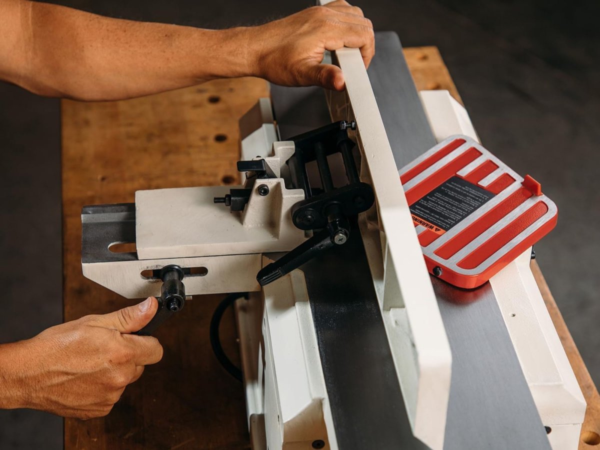 man working on a benchtop jointer