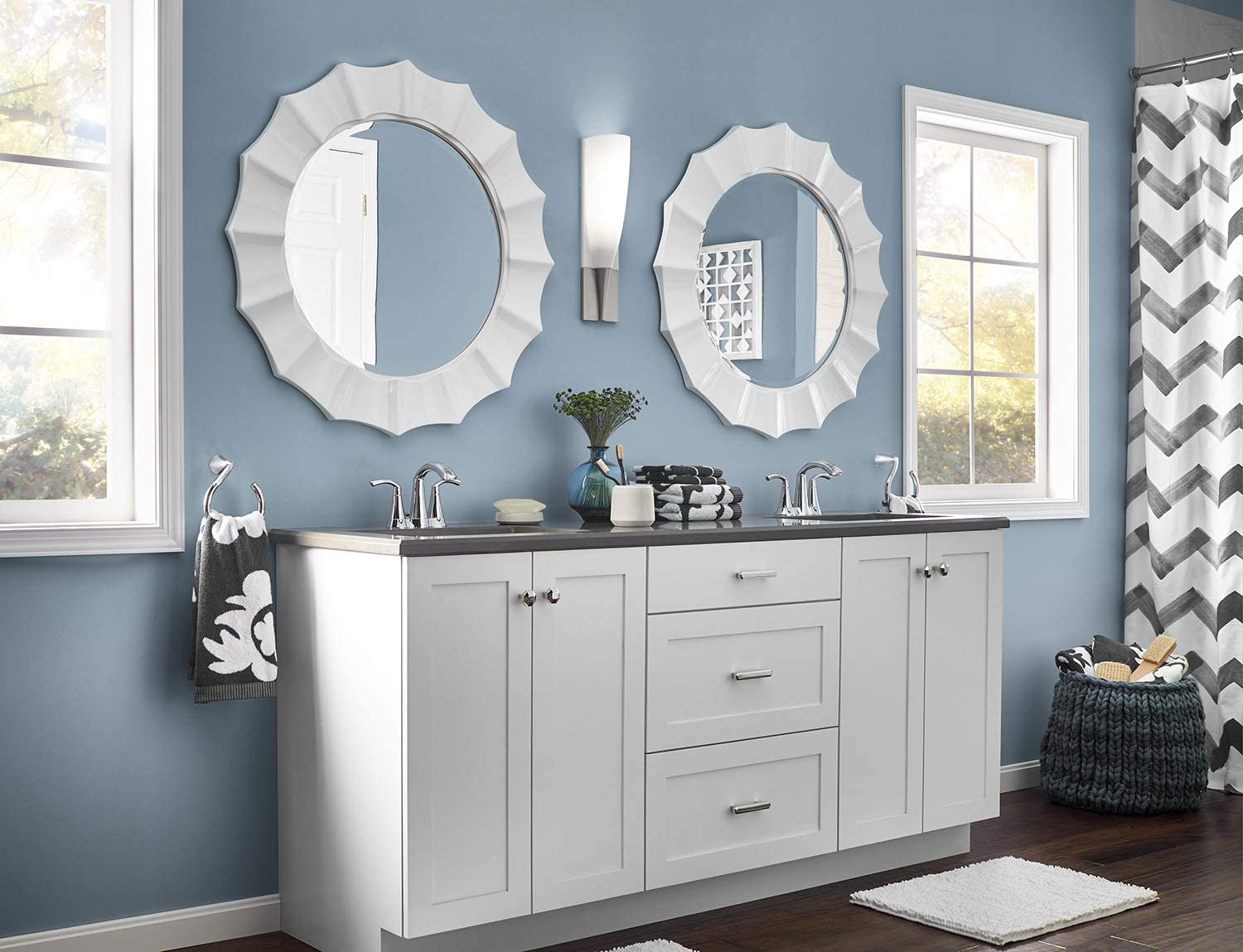 A bathroom vanity and mirrors with blue painted walls