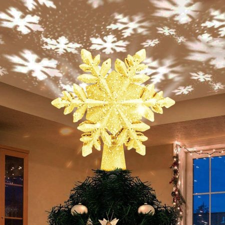  The Yostyle Christmas Tree Topper on a tree and projecting bright snowflakes onto the ceiling of a dimly lit room.