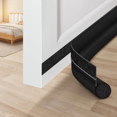 Maxtid black Adjustable Door Draft Stopper on bottom of white door