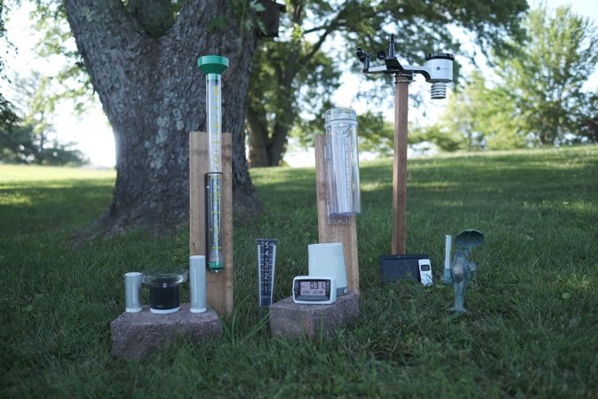 Multiple rain gauges lined up outside on the lawn