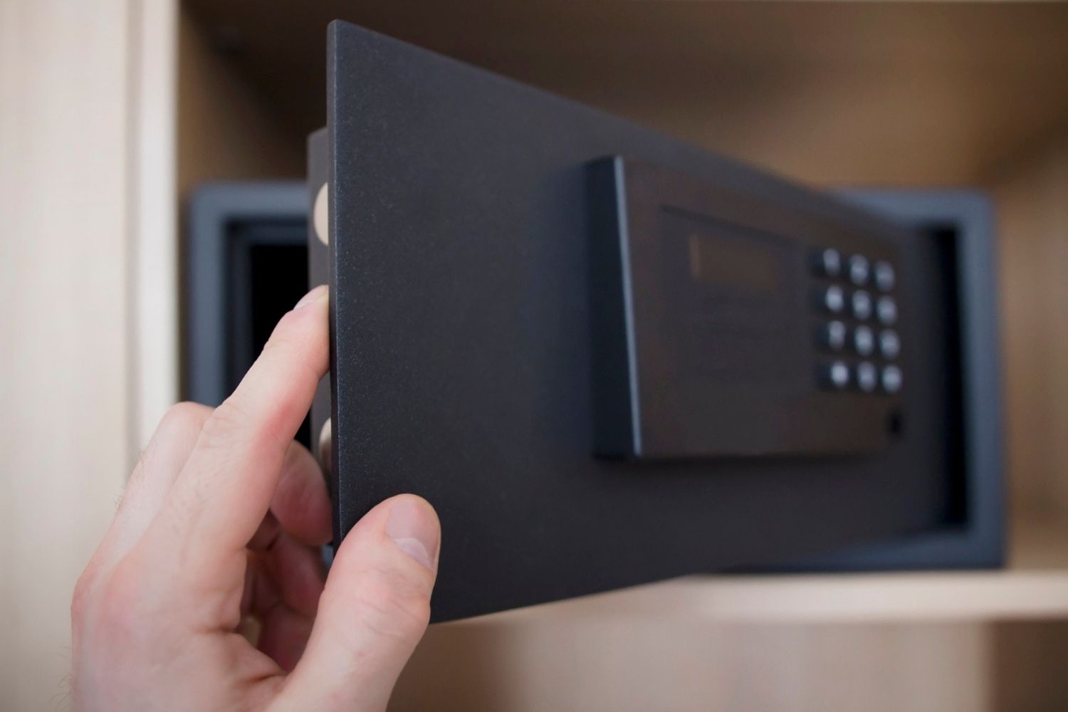 A close-up of a person's hand on the open door of the best fireproof safe option