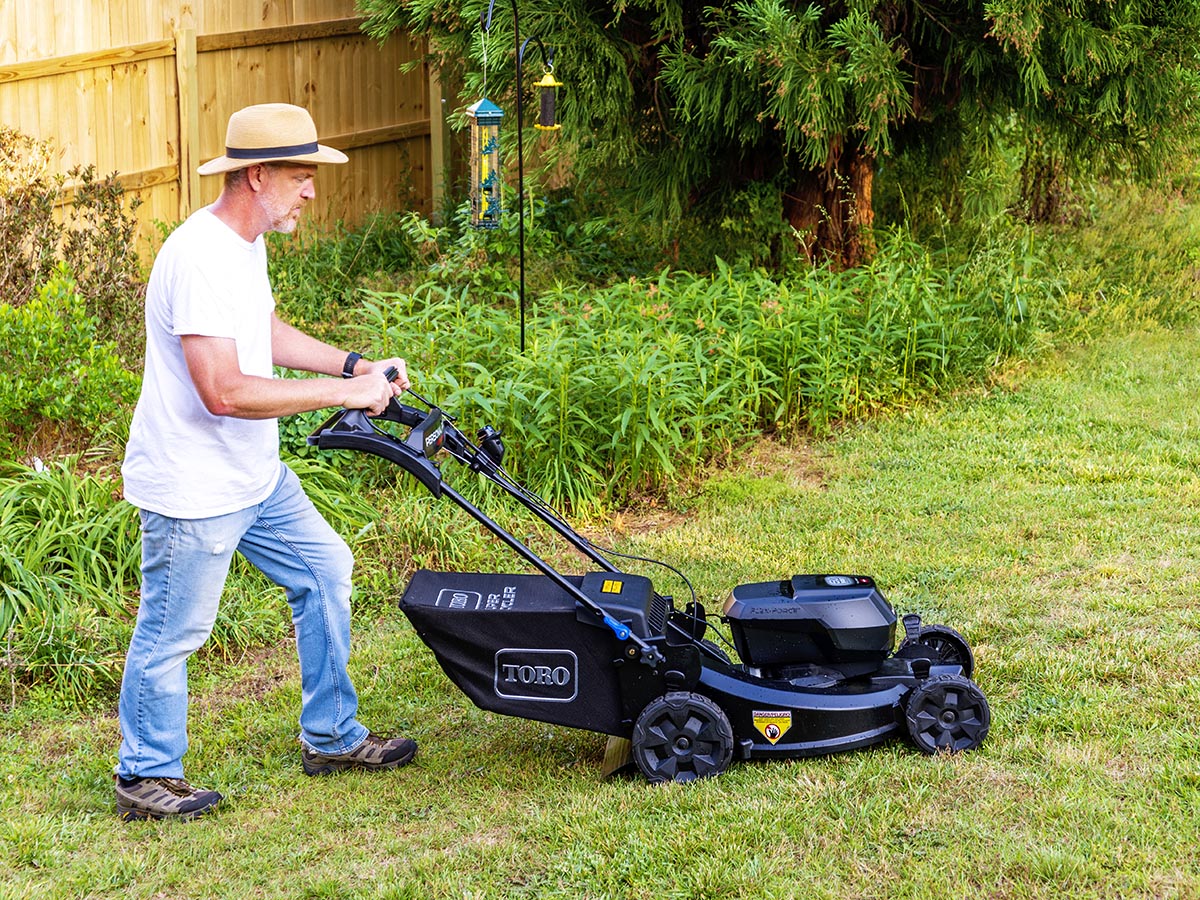 Tester pushing Toro lawn mower on grass