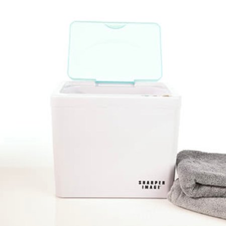  The Sharper Image Towel Warmer on a white table with two folded gray towels next to it.