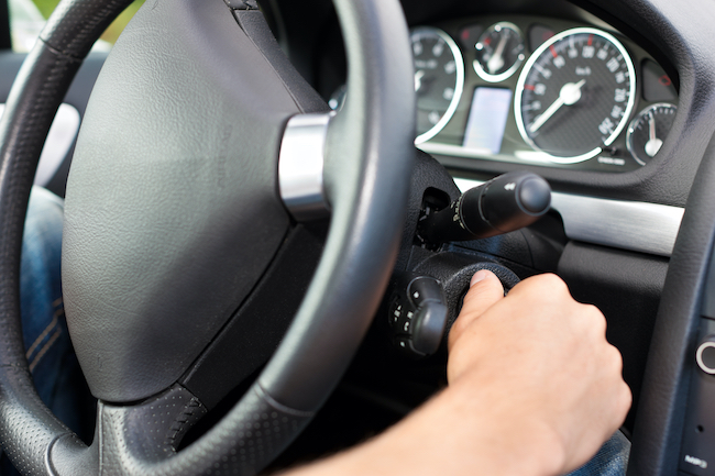 Man turning the ignition key of his car