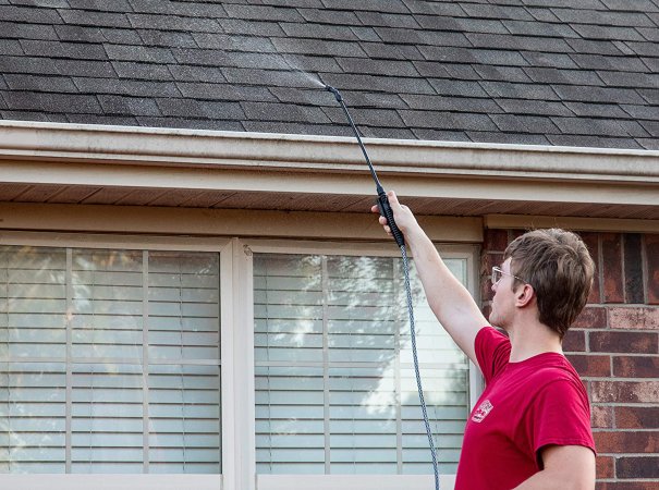 Man using a sprayer on a roof