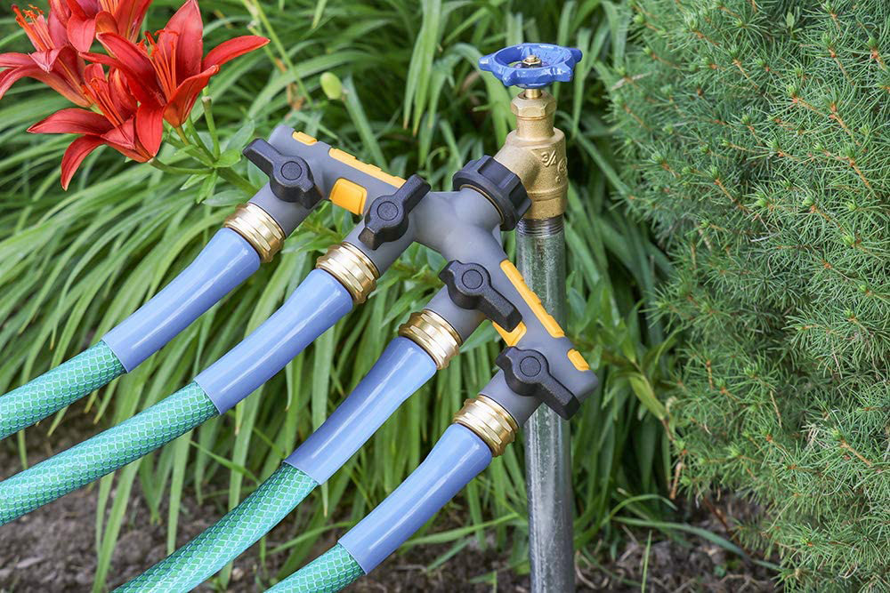 A hose splitter with four hose attached to it outside in the garden