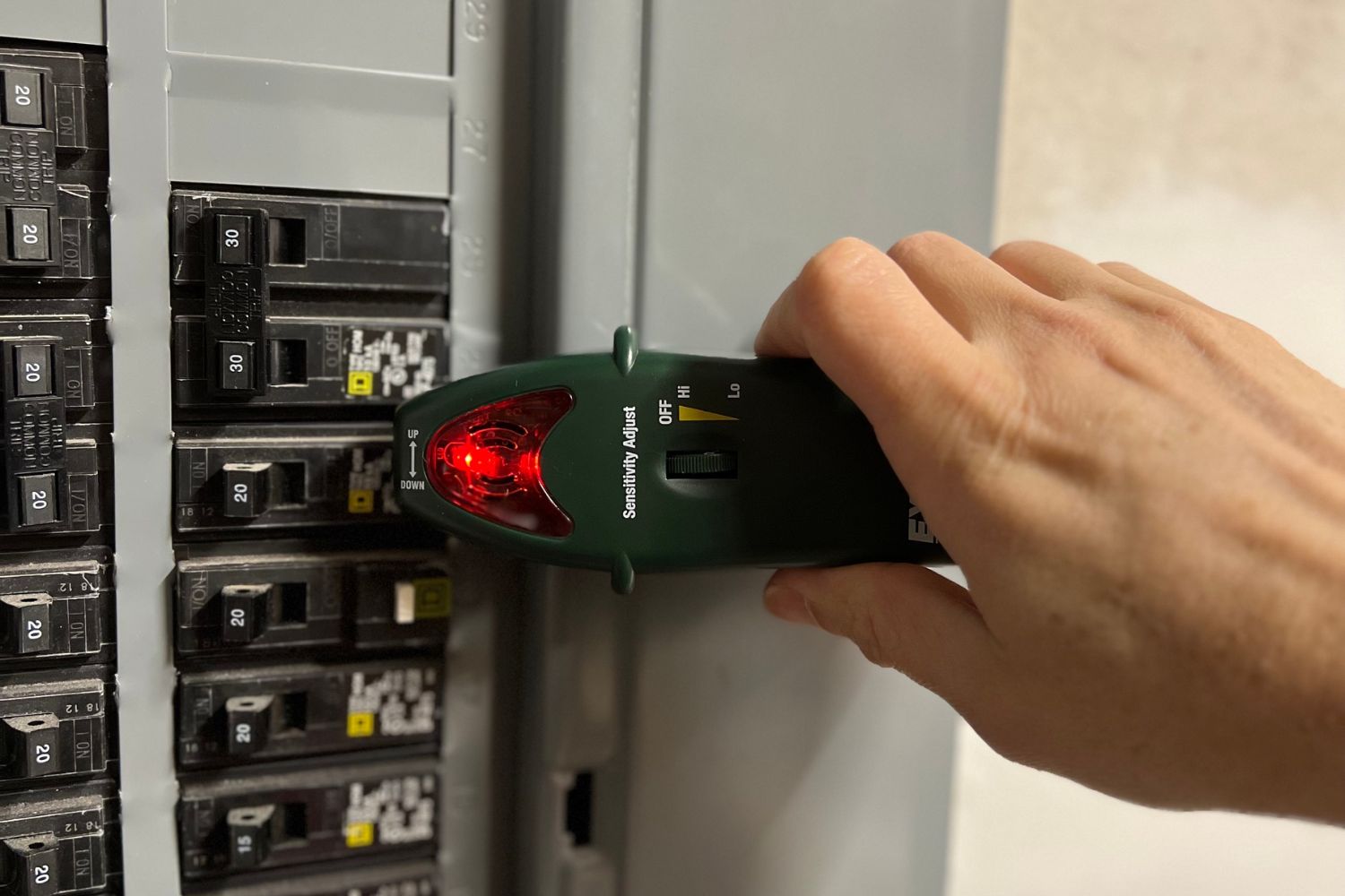 A circuit breaker finder being used on an electrical panel