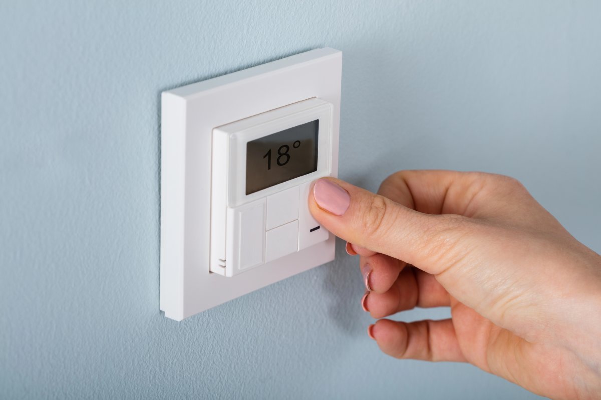 A hand setting one of the Best Non Programmable Thermostat 