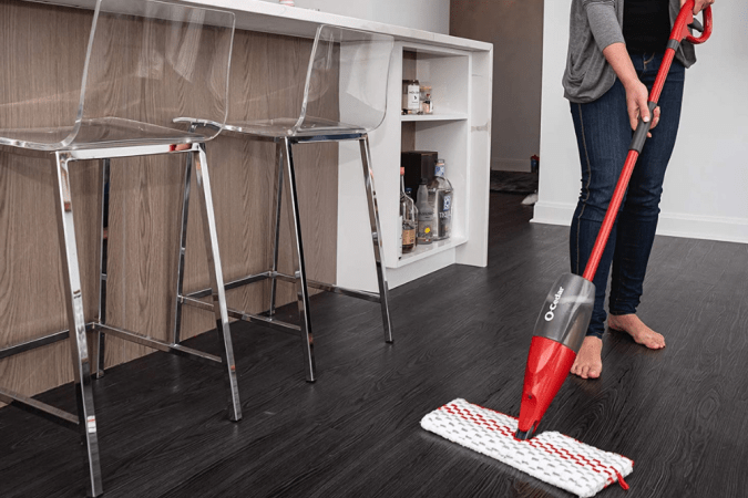 A person using the best mop for laminate floors to clean a kitchen floor