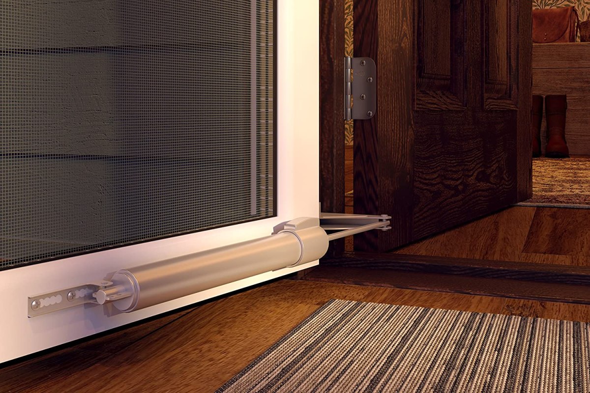 Closeup of a screen door opener on the bottom of a door
