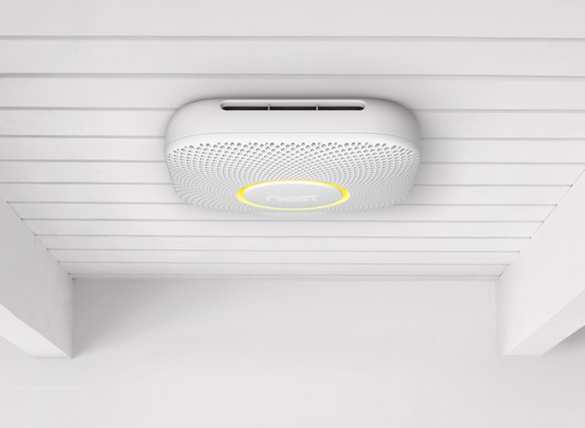 A smart smoke detector device installed on the ceiling.