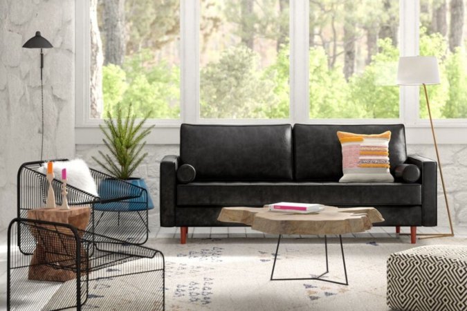 The best leather sofa option set up in a modern boho living room in front of a large window