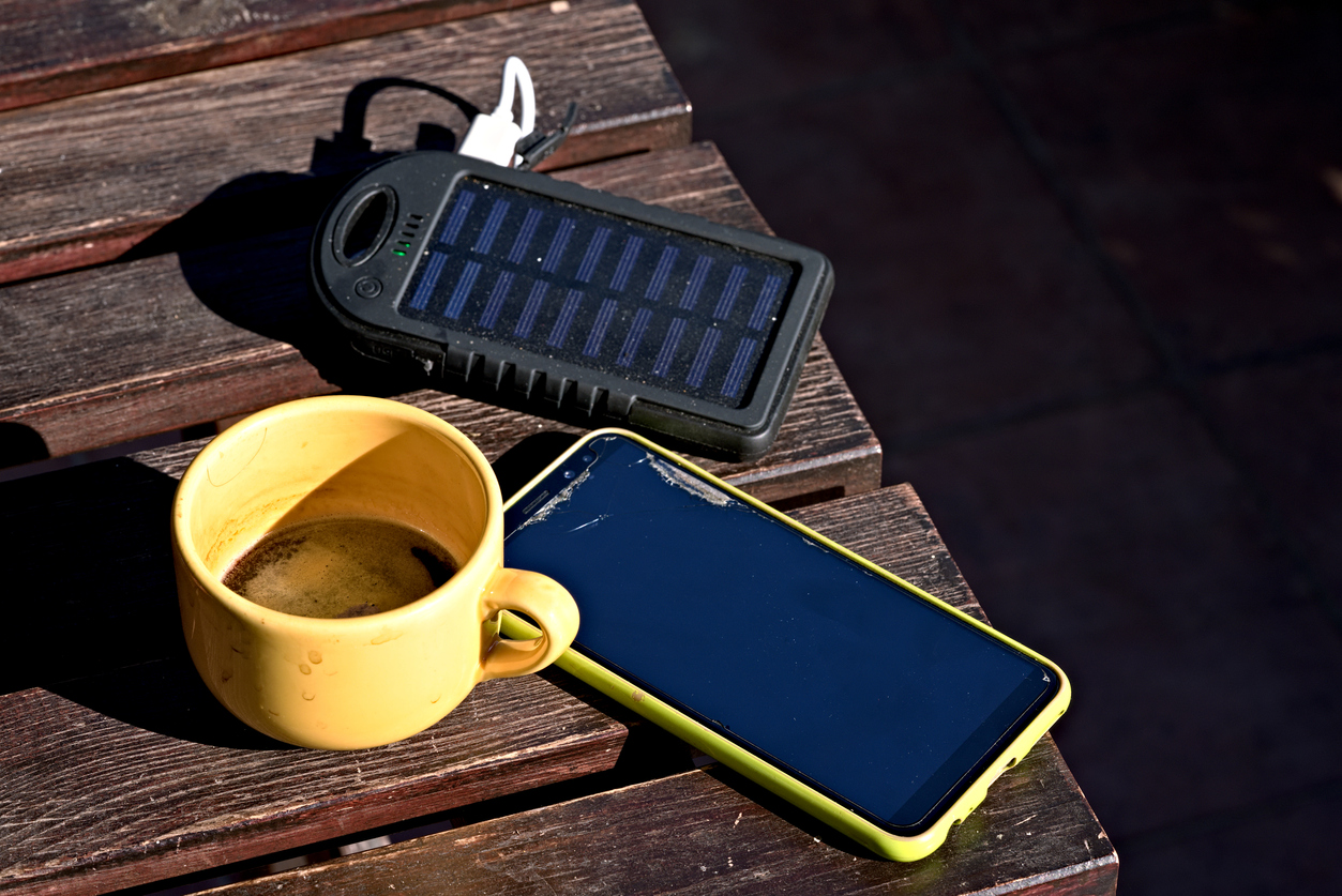 smartphone, power bank and a cup of coffee on the porch