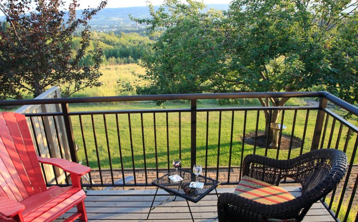 Balcony deck with patio furniture and metal railings.