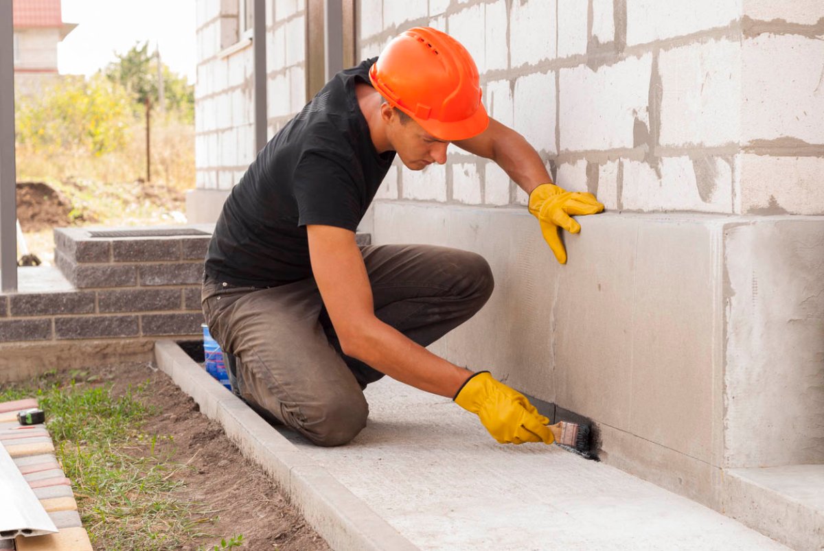 A worker repairs a foundation.