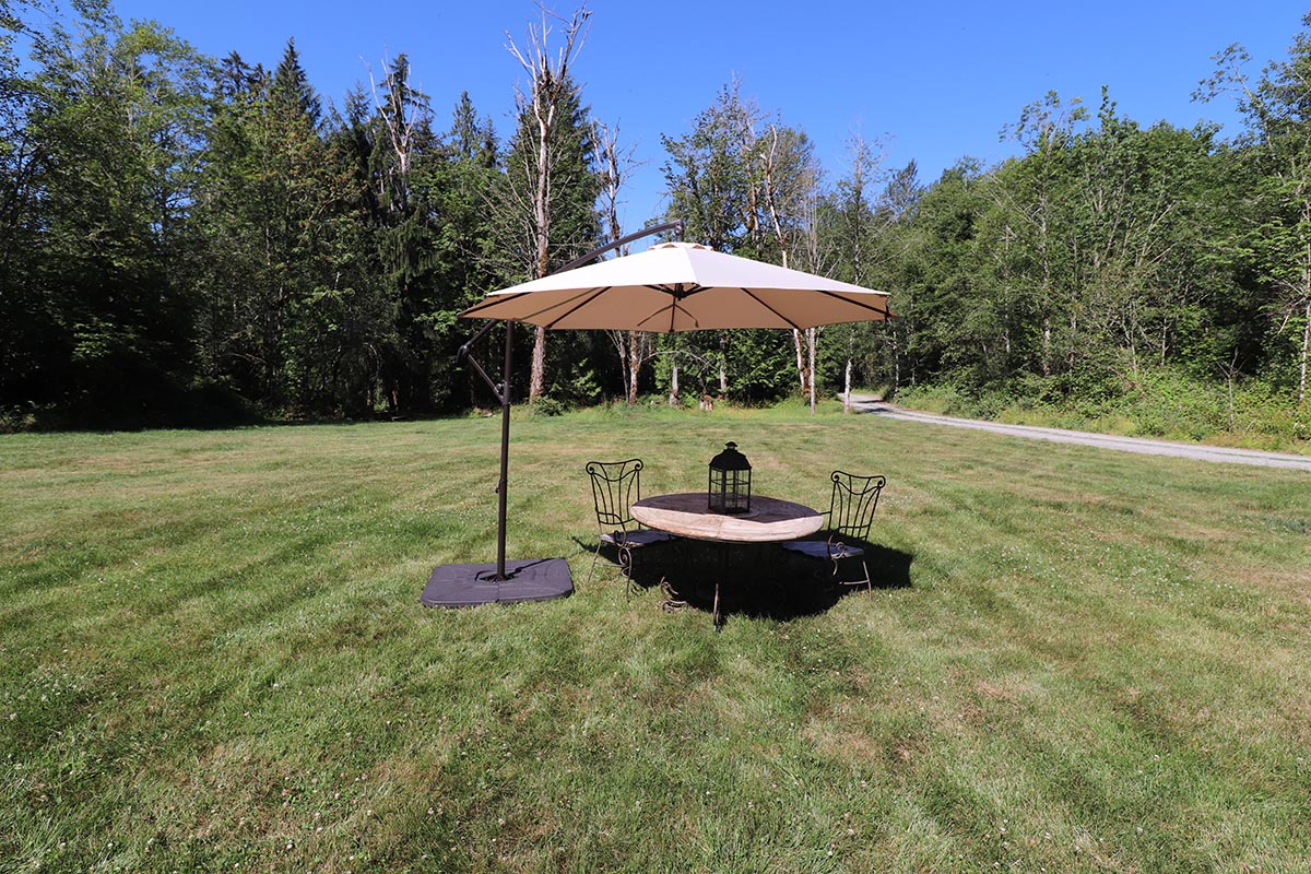 The best cantilever umbrella option set up over a patio table in a sunny backyard