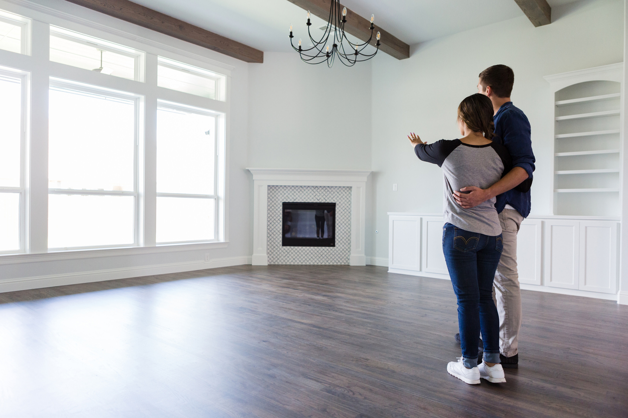 Rear view of a young couple planning the decor in the living room in their new home.