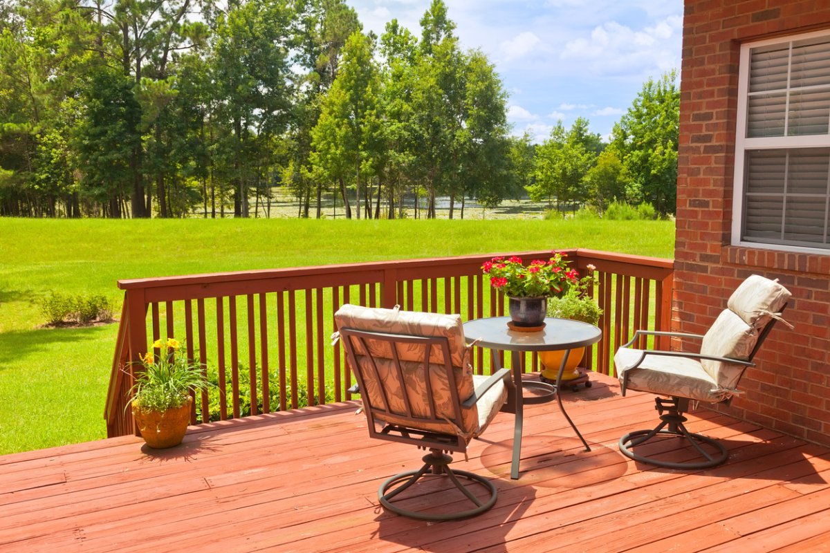 Residential backyard deck overlooking lawn and lake