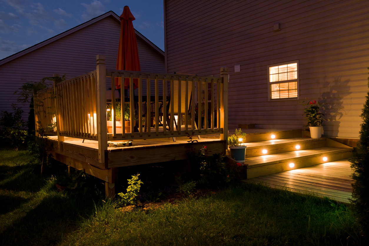 Wooden deck and patio of family home at night.