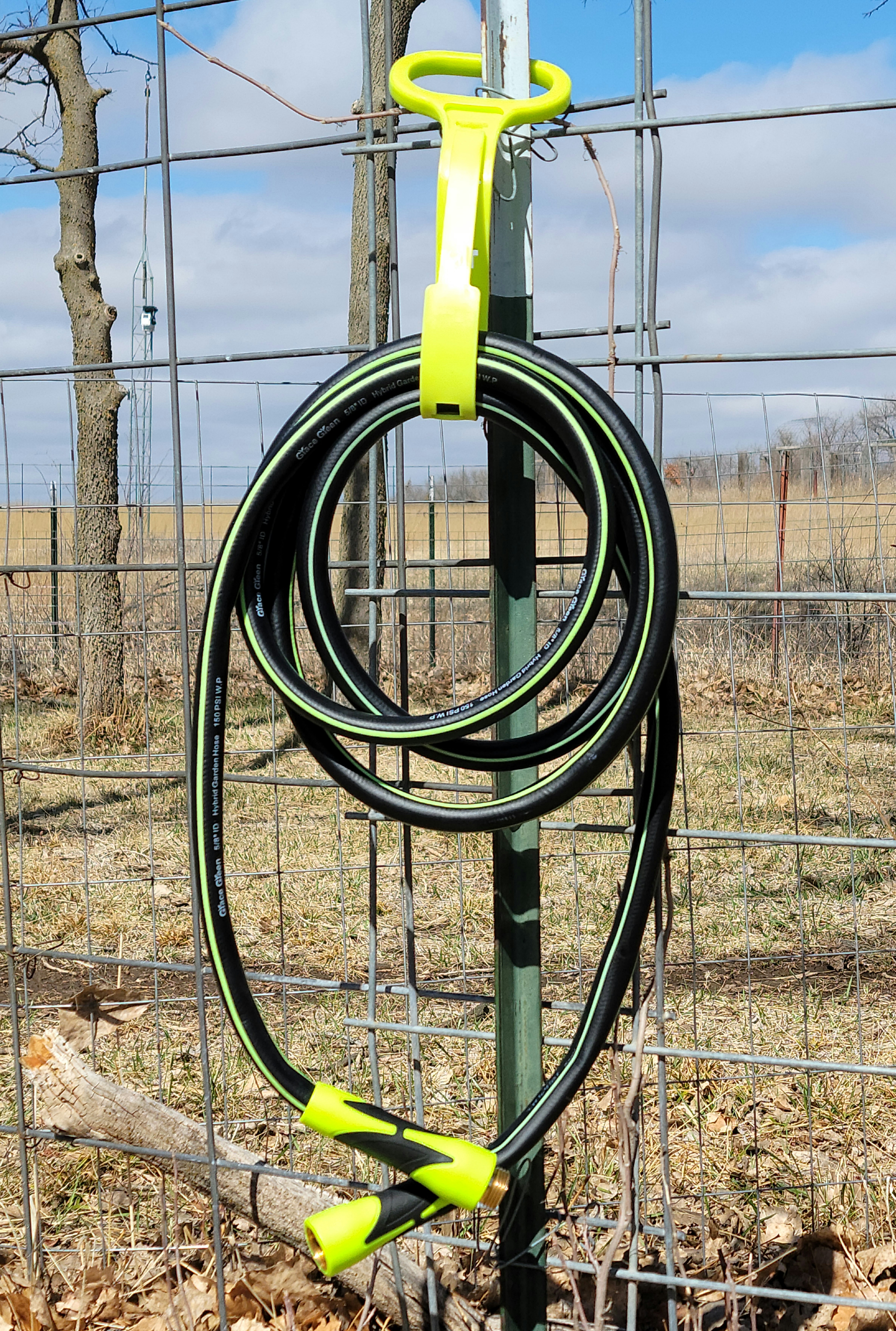 garden hose wrapped up on fence