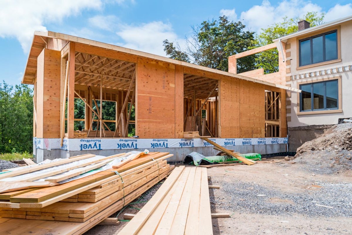 A partially built house with lumber lying outside