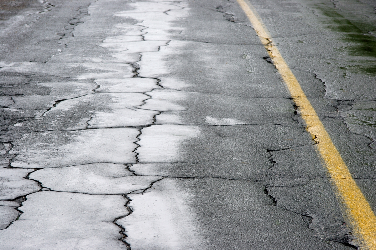 Multiple visible cracks on the frozen road.