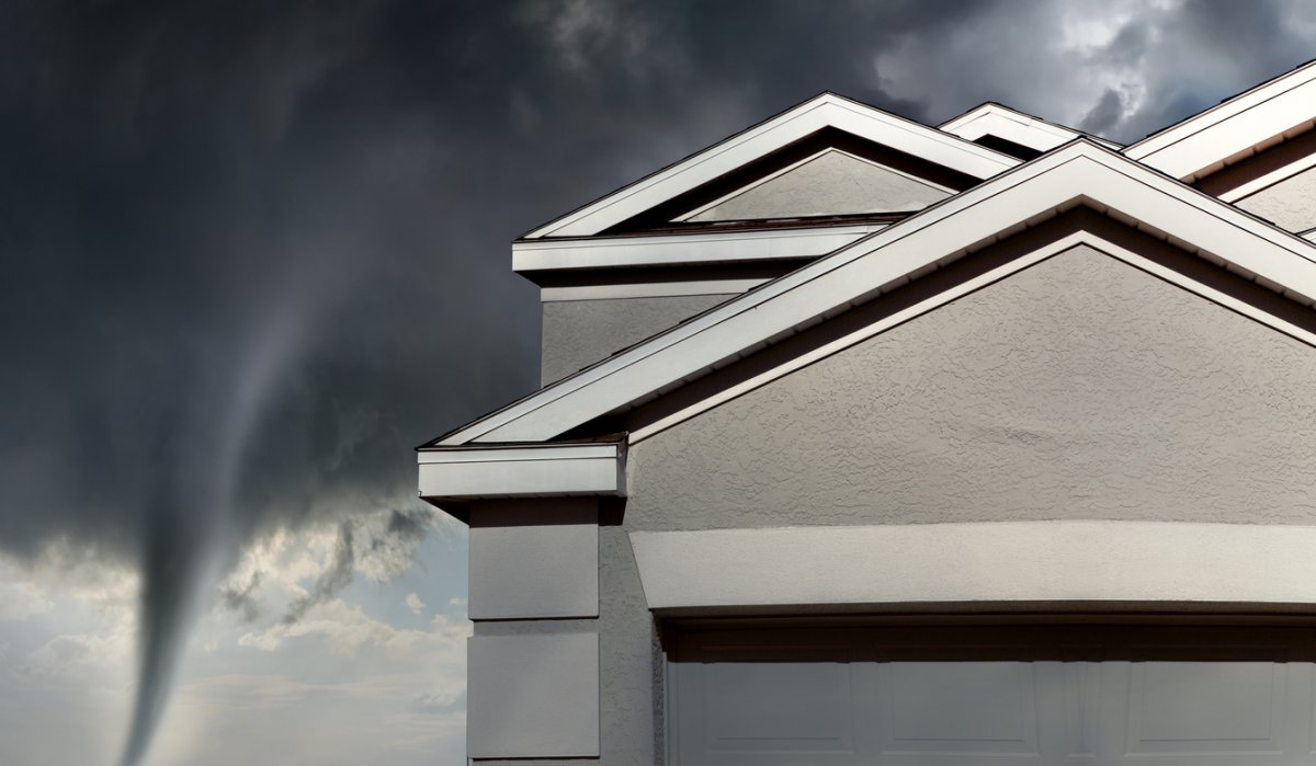 Tornado forming behind a suburban home, presumably during tornado season