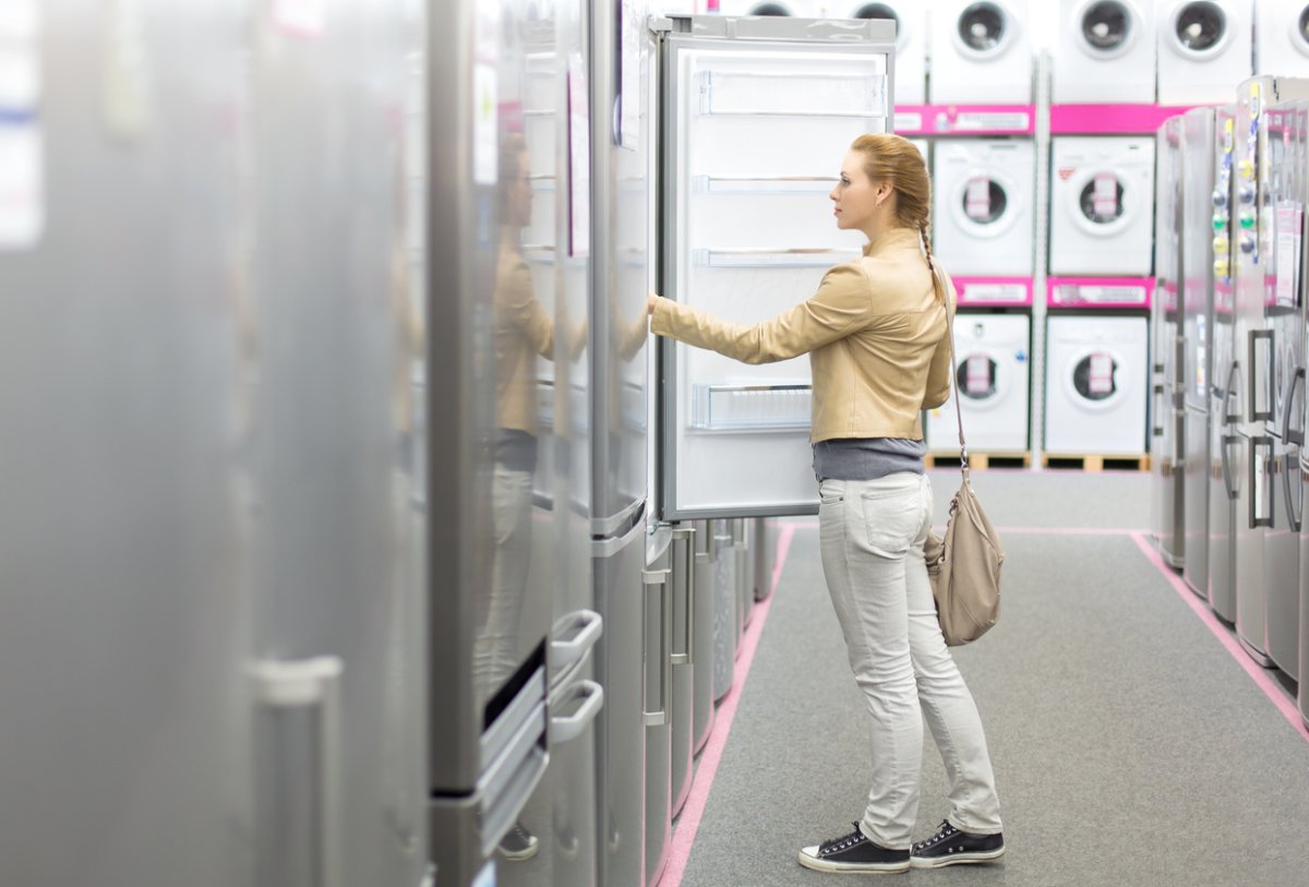 woman buys the refrigerator in shop