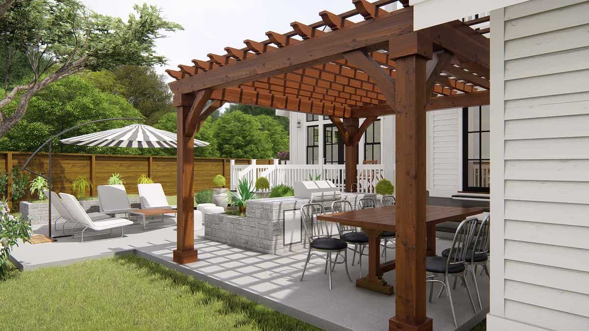 Lawn furniture on a patio is underneath a wooden pergola attached to the side of a white home.