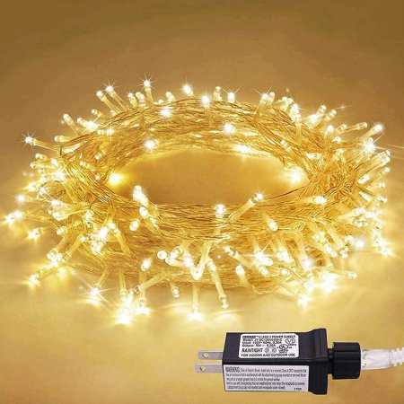  The JMEXSUSS 33-Foot 100 LED Indoor String Lights wound in a circle and set on a counter providing a warm yellow glow.