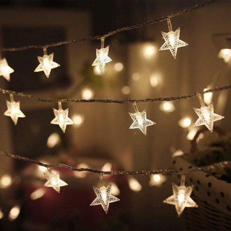  Three rows of the Twinkle Star 100 LED Star String Lights strung up before a blurred background.