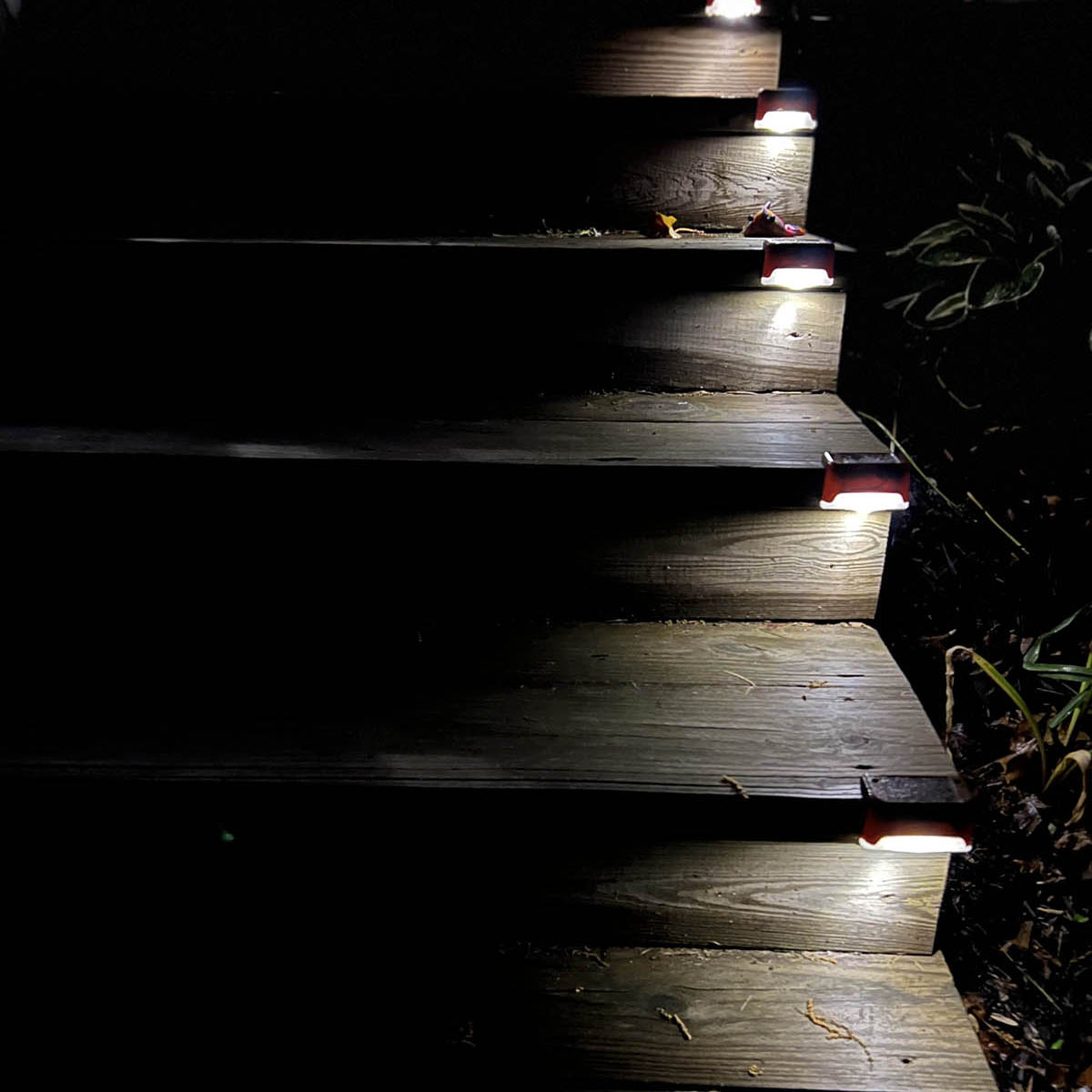 Wooden outdoor stairs, each illuminated with a step light