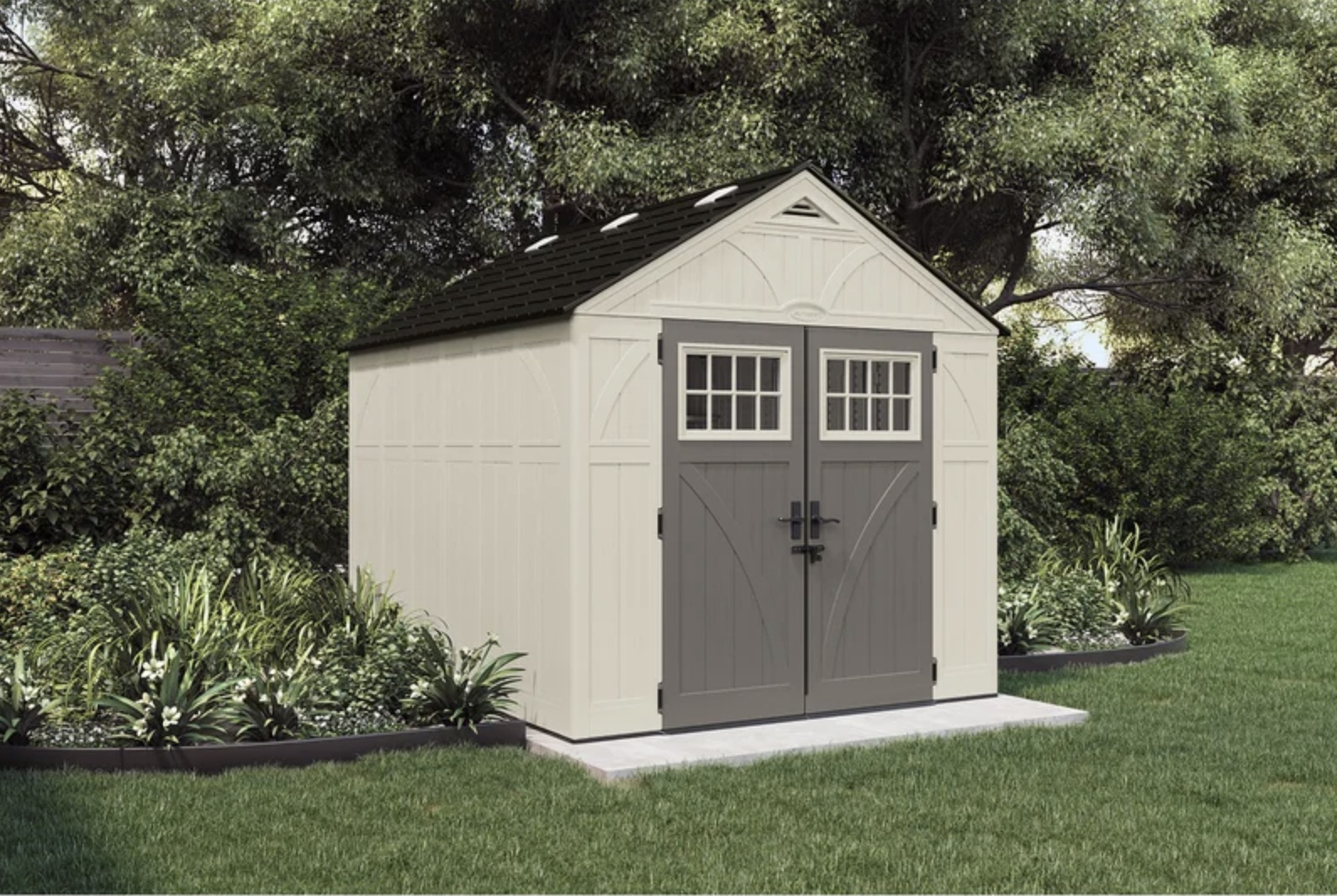 A beige backyard shed with grey double doors.